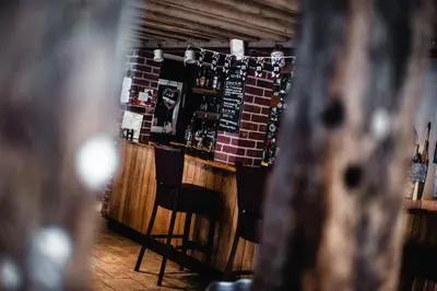 a bar with chairs and a brick wall at The Kings Head in New Buckenham