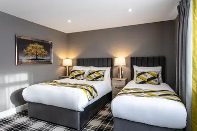 two beds in a hotel room with two lamps at Roydon Marina Village Hotel in Roydon