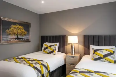 a bedroom with two beds and a lamp at Roydon Marina Village Hotel in Roydon