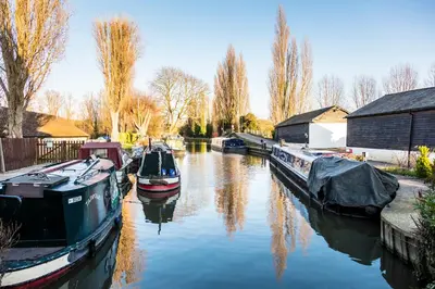 a group of boats are docked in a canal at Roydon Marina Village Hotel in Roydon