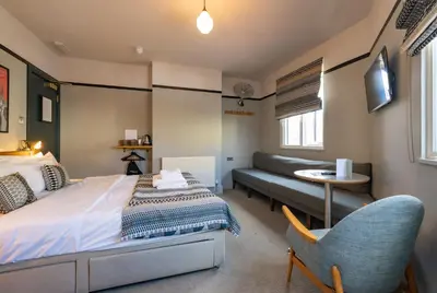 a bedroom with a bed and a couch and a table at The Waterman in Cambridge