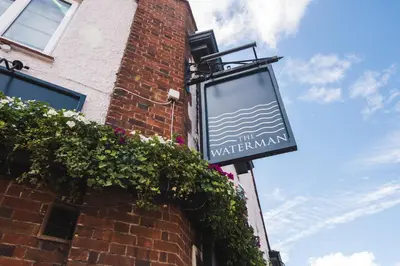 a sign on the side of a brick building at The Waterman in Cambridge