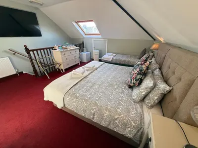a attic bedroom with a bed and a couch at Cambridge Bed & Breakfast in Cambridge
