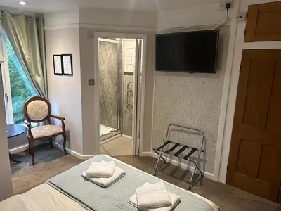 a bedroom with a bed and a television on the wall at Cambridge Bed & Breakfast in Cambridge