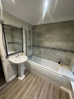 a bathroom with a sink and a tub and a mirror at Cambridge Bed & Breakfast in Cambridge
