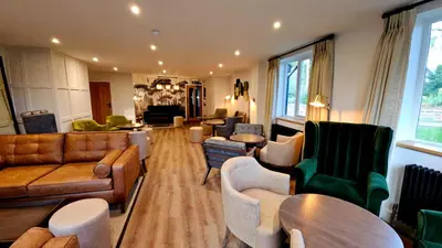 a living room with couches and chairs and tables at Great Hallingbury Manor & Lodges London Stansted in Bishops Stortford