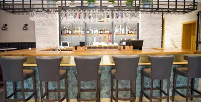 a bar with bar stools in a restaurant at Great Hallingbury Manor & Lodges London Stansted in Bishops Stortford