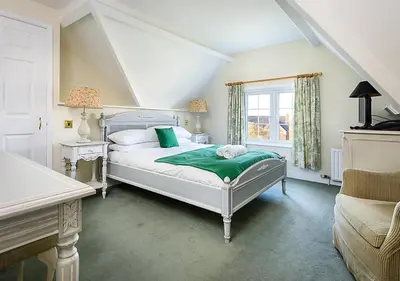 a white bedroom with a bed and a window at Sherbourne House in Attleborough