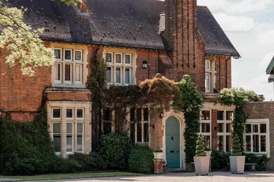 an old brick house with a blue door at Pontlands Park Hotel in Chelmsford
