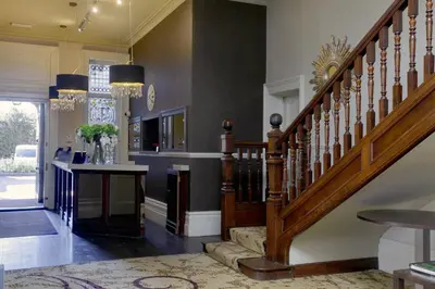 a staircase in a living room with a stair case at Pontlands Park Hotel in Chelmsford