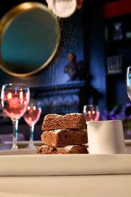 a plate of brownies and wine glasses on a table at J.D.Young in Harleston