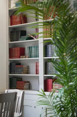 a white book shelf filled with lots of books at J.D.Young in Harleston