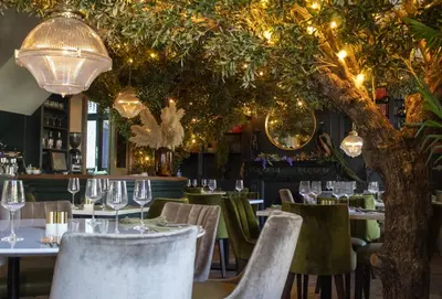 a restaurant with tables and chairs with lights at J.D.Young in Harleston
