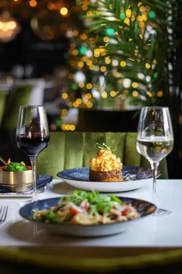 a table with two plates of food and wine glasses at J.D.Young in Harleston