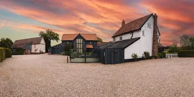 a group of buildings with a cloudy sky in the background at The Auberge in Yaxley