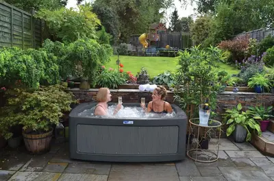 two women in a hot tub in a garden at Corner Farm in Halesworth
