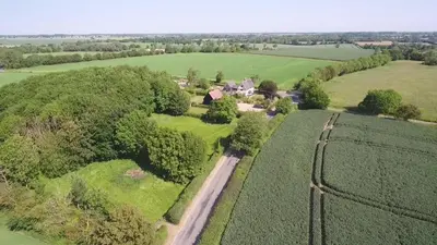 an aerial view of a farm with a train track at Corner Farm in Halesworth