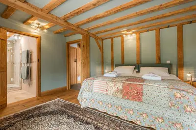 a bedroom with a large bed in a room at Corner Farm in Halesworth