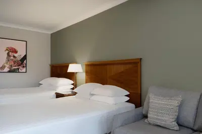 a hotel room with two beds and a chair at Delta Hotels by Marriott Waltham Abbey in Waltham Abbey