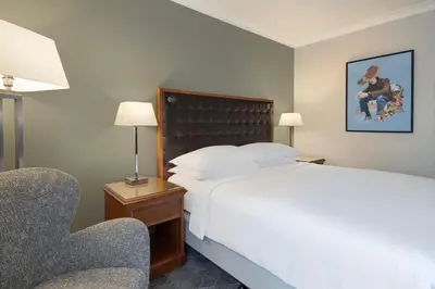 a hotel room with a bed and a chair at Delta Hotels by Marriott Waltham Abbey in Waltham Abbey
