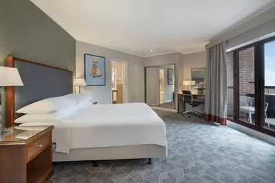 a bedroom with a large white bed and a desk at Delta Hotels by Marriott Waltham Abbey in Waltham Abbey