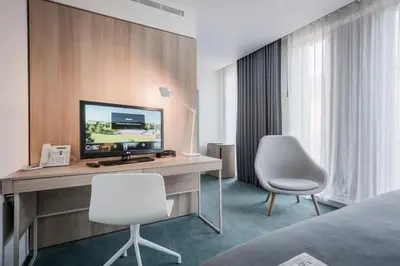 a hotel room with a desk with a television and two chairs at Hinxton Hall Hotel and Conference Centre in Hinxton