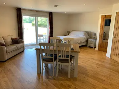 a living room with a bed and a table and chairs at Plumptons Farm Holiday Lodges in Colchester