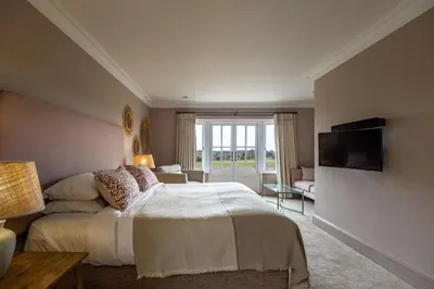 a bedroom with a large bed and a television at The Crown Inn in Stoke by Nayland