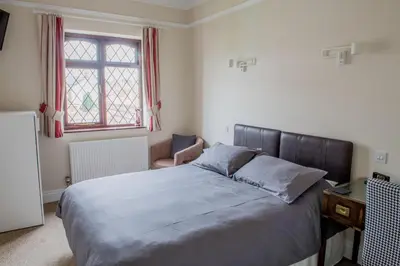 a bedroom with a bed and a desk and a window at Toothbrush Rooms at Lattice Lodge - Guest Kitchen & EV Recharging in Ipswich