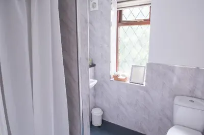 a bathroom with a toilet and a window at Toothbrush Rooms at Lattice Lodge - Guest Kitchen & EV Recharging in Ipswich