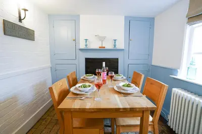 a wooden table with plates of food on it at Aldeburgh Cottage in Aldeburgh