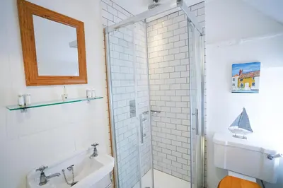 a bathroom with a shower and a sink at Aldeburgh Cottage in Aldeburgh