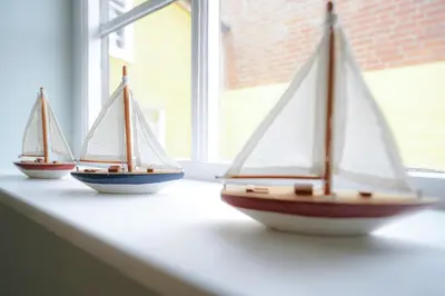 three miniature sailboats sitting on a window sill at Aldeburgh Cottage in Aldeburgh