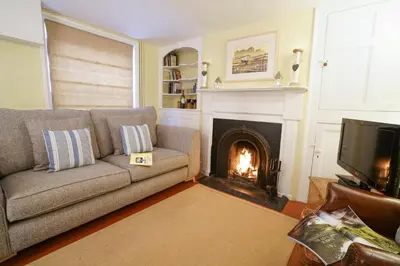 a living room with a couch and a fireplace at Aldeburgh Cottage in Aldeburgh