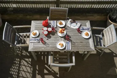 a wooden table with plates of food on it at 1 South Cottages in Thorpeness