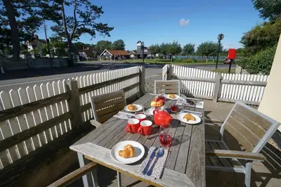 a wooden table with plates of food on it at 1 South Cottages in Thorpeness