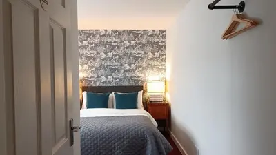 a bedroom with a bed with blue pillows at Stansted Lodge Elsenham in Elsenham