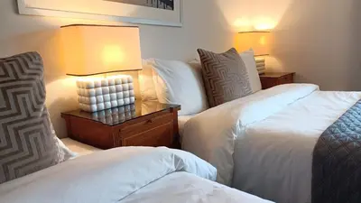 a hotel room with two beds and a lamp at Stansted Lodge Elsenham in Elsenham