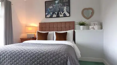 a bedroom with a bed and a picture on the wall at Stansted Lodge Elsenham in Elsenham