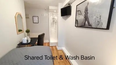 a room with a bed and a table and a television at Stansted Lodge Elsenham in Elsenham