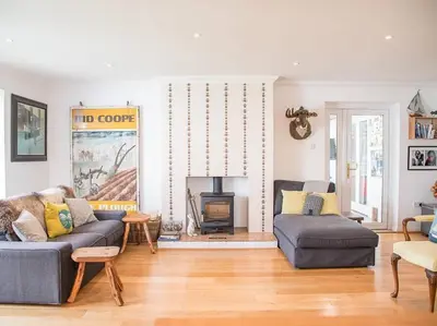 a living room with a couch and a fireplace at Honeybee Cottage, Orford in Orford