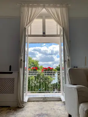 an open window with a view of a balcony with red flowers at Pier View Self Catering Luxury Apartments in Southend-on-Sea