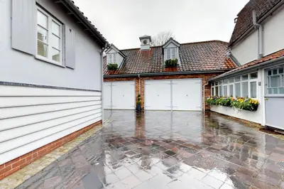 a courtyard of a house with white garage doors at Panfield House in Braintree