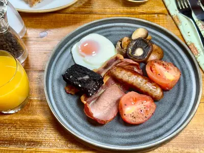 a plate of breakfast food with eggs bacon and mushrooms at Sibton White Horse Inn in Saxmundham