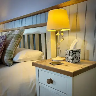 a lamp on a night stand next to a bed at Sibton White Horse Inn in Saxmundham