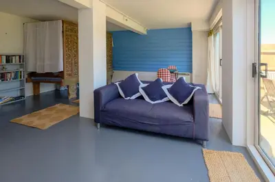 a living room with a purple couch with pillows at The Dairy Cottage in Aldeburgh