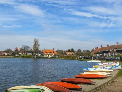 a row of boats are lined up on the water at The Dairy Cottage in Aldeburgh
