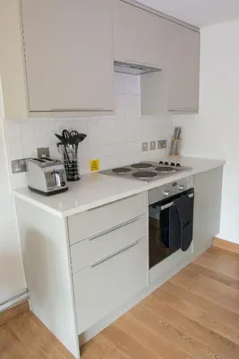 a kitchen with white cabinets and a stove top oven at West Court- Jesus College in Cambridge