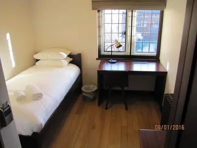 a bedroom with a desk and a bed and a window at West Court- Jesus College in Cambridge