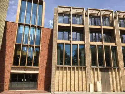 a brick building with large windows on the side of it at West Court- Jesus College in Cambridge